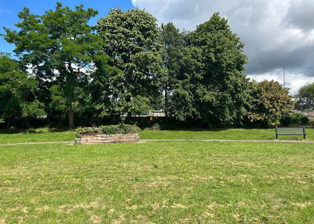 View from the Lock Lane Centre in Castleford. Green grass, park bench and trees